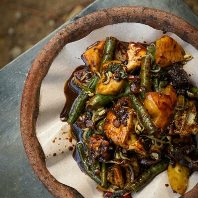 A flavorful Indonesian vegetable dish served in a rustic stone bowl, showcasing traditional flavors.